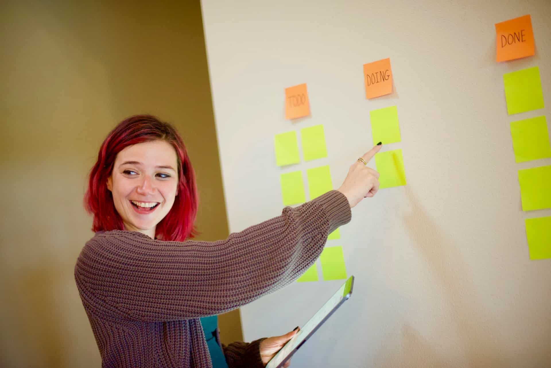 Lady pointing to a Kanban board
