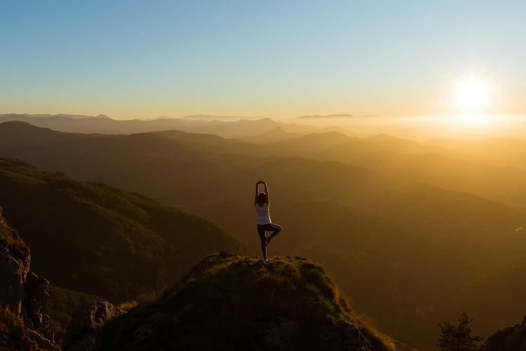 spiritual yoga pose on top of a mountain