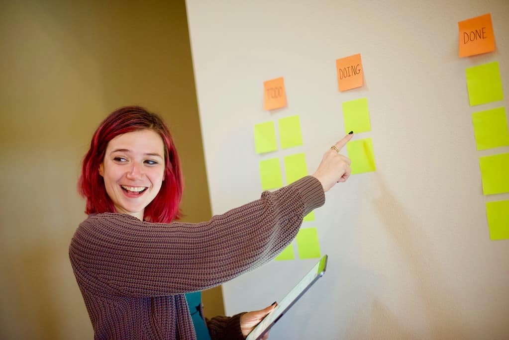 Lady pointing to a Kanban board